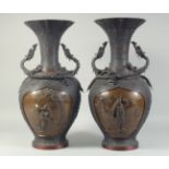 AN EXCEPTIONAL PAIR OF JAPANESE BRONZE SAMURAI VASES, the panel on each with relief samurai