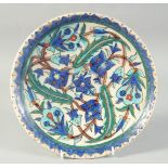 A 19TH CENTURY TURKISH KUTAHYA GLAZED POTTERY PLATE, 25.5cm diameter.