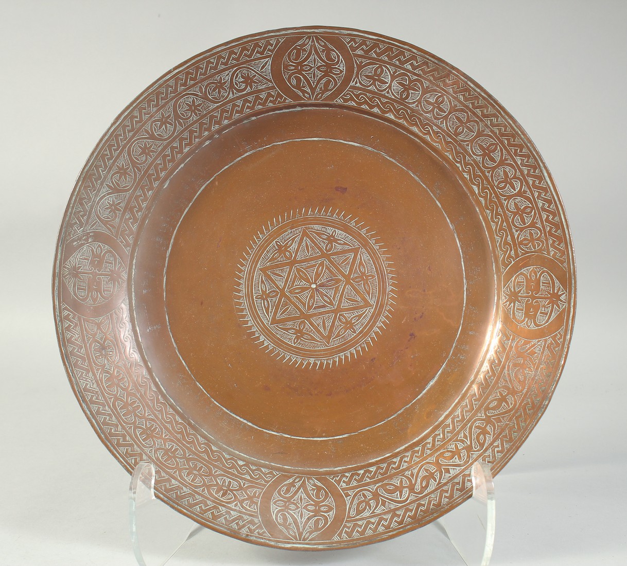 AN ENGRAVED COPPER DISH, 34cm diameter.