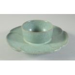A CHINESE CELADON CRACKLE GLAZE TEA CUP STAND, with petal form rim and incised characters, 17cm