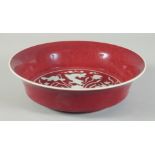 A CHINESE IRON RED PORCELAIN BOWL, with incised white fish and aquatic flora to the centre, six-