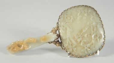 A CHINESE CARVED JADE HAND MIRROR, with metal mounts, the handle made from a carved jade belt hook