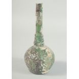 AN EARLY ISLAMIC GREEN GLASS BOTTLE, 20cm high.