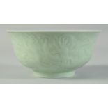 A CHINESE CELADON CARVED DRAGON RESTAURANT BOWL, with characters to the base, 15cm diameter.