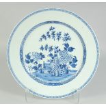 A CHINESE BLUE AND WHITE PORCELAIN CHARGER, painted with central panel of native flora, 38.5cm