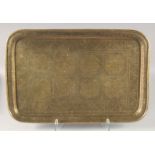 A LARGE 19TH CENTURY PERSIAN QAJAR ENGRAVED BRASS TRAY, 58.5cm x 38cm.