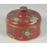 A CHINESE RED GROUND CLOISONNE CIRCULAR BOX AND COVER, decorated with flora, 12.5cm diameter.