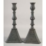 A PAIR OF PERSIAN QAJAR BRONZE CANDLESTICKS, with engraved decoration, 37cm high.