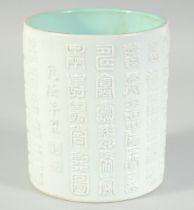 A CHINESE WHITE AND TURQUOISE GLAZE PORCELAIN BRUSH POT, with relief columns of characters, the base