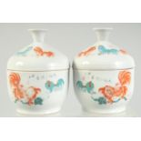 A PAIR OF CHINESE CORAL RED AND WHITE PORCELAIN LIDDED BOWLS, painted with beasts and calligraphy,