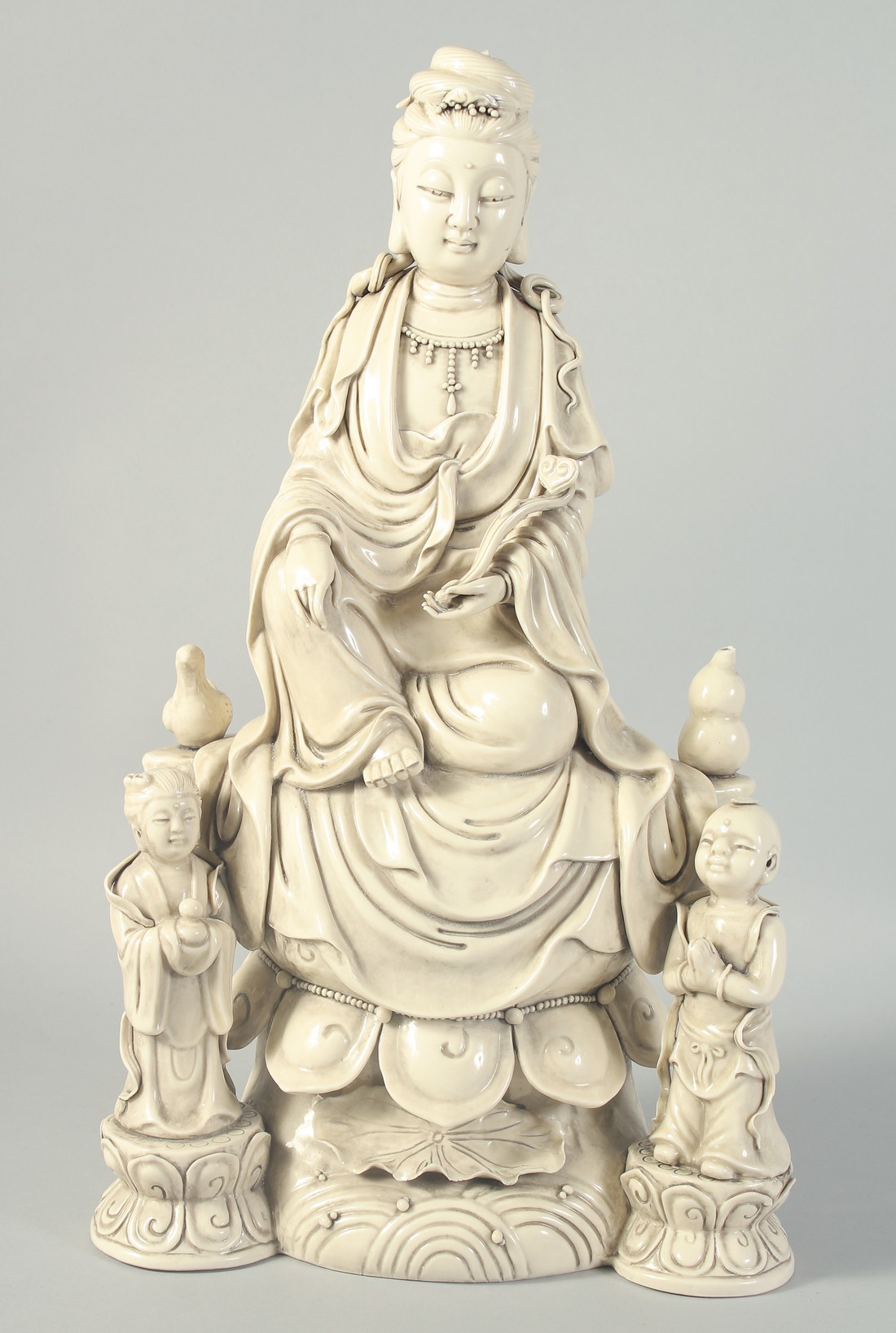 A LARGE BLANC-DE-CHINE GUANYIN AND CHILDREN, 46.5cm high.