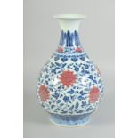A CHINESE BLUE, WHITE AND UNDERGLAZE RED PORCELAIN VASE, decorated with lotus and scrolling vine,