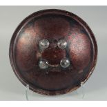 AN INDIAN PAINTED AND LACQUERED LEATHER DHAL SHIELD, 34cm diameter.