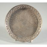 A SMALL ENGRAVED ISLAMIC DISH, with calligraphy, 10cm diameter.