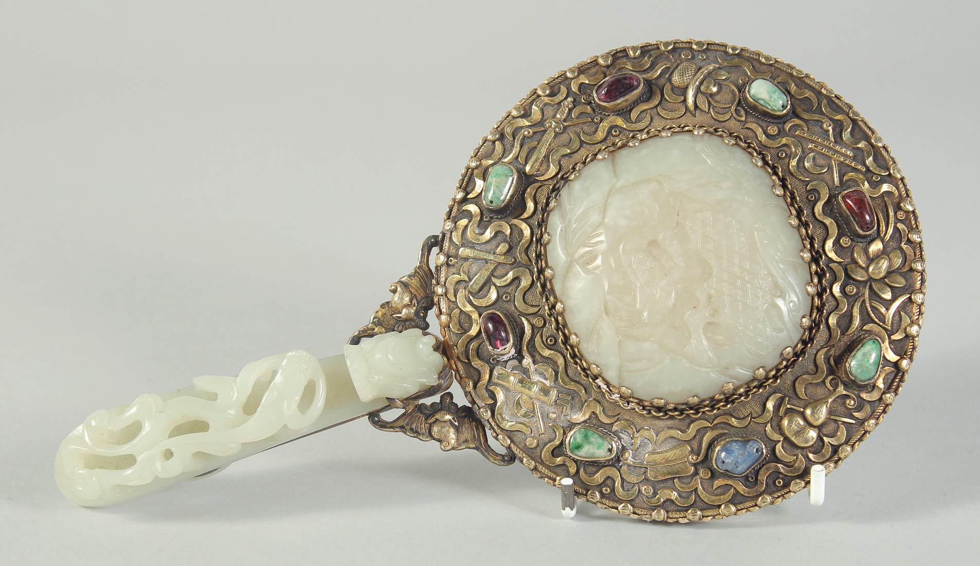 A CHINESE CARVED JADE AND GILT METAL HAND MIRROR, the handle made from a carved jade chilong belt