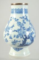 A CHINESE TRANSITIONAL BLUE AND WHITE PORCELAIN VASE, painted with flora, (neck cut with silver