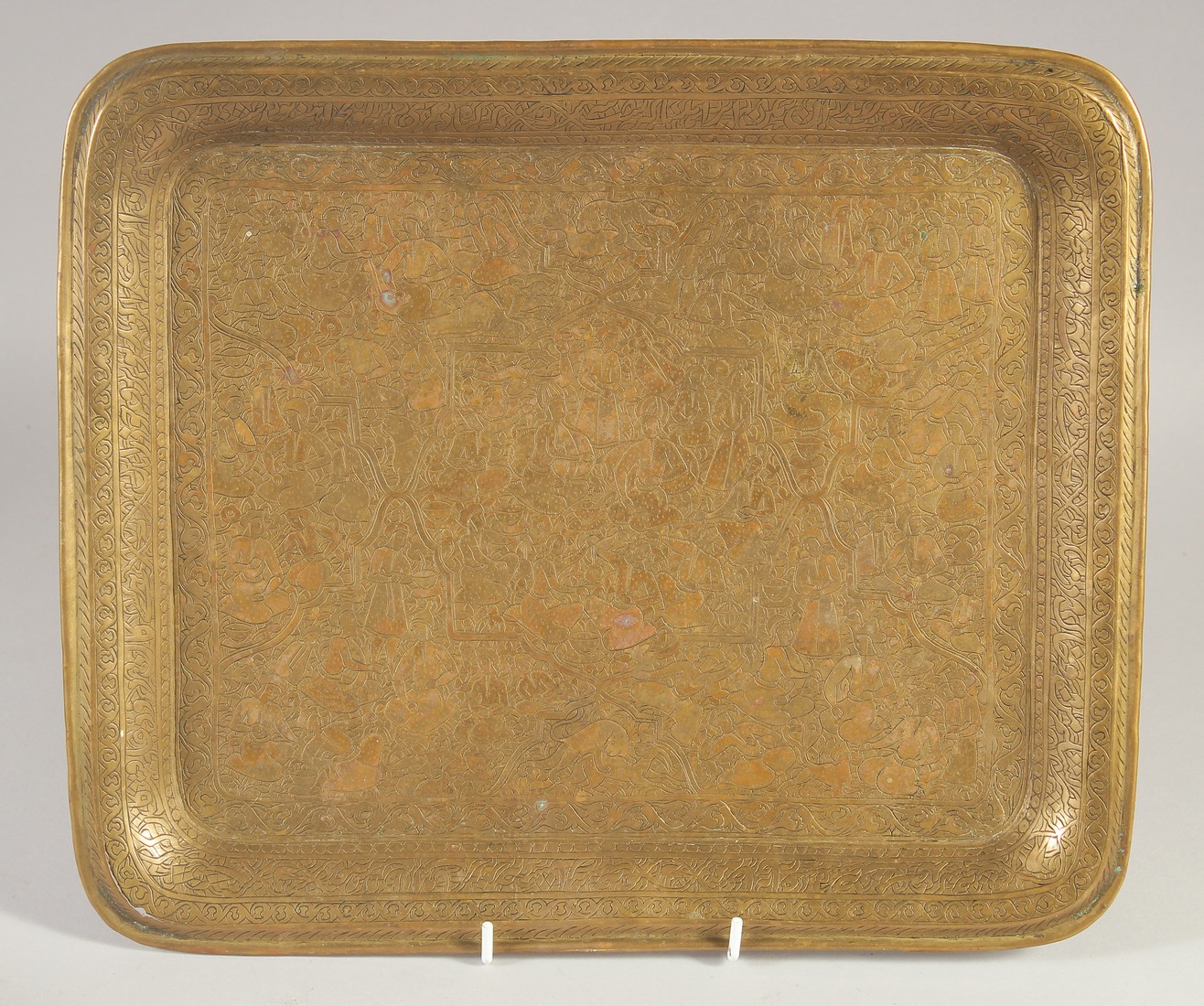 A 19TH CENTURY PERSIAN ENGRAVED BRASS TRAY, decorated with various figures and animals, 34cm x