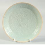 A CHINESE CARVED PEACOCK YINQING GLAZE DISH, 20.5cm diameter.