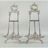 A LARGE PAIR OF SILVERED EASELS 20ins high.