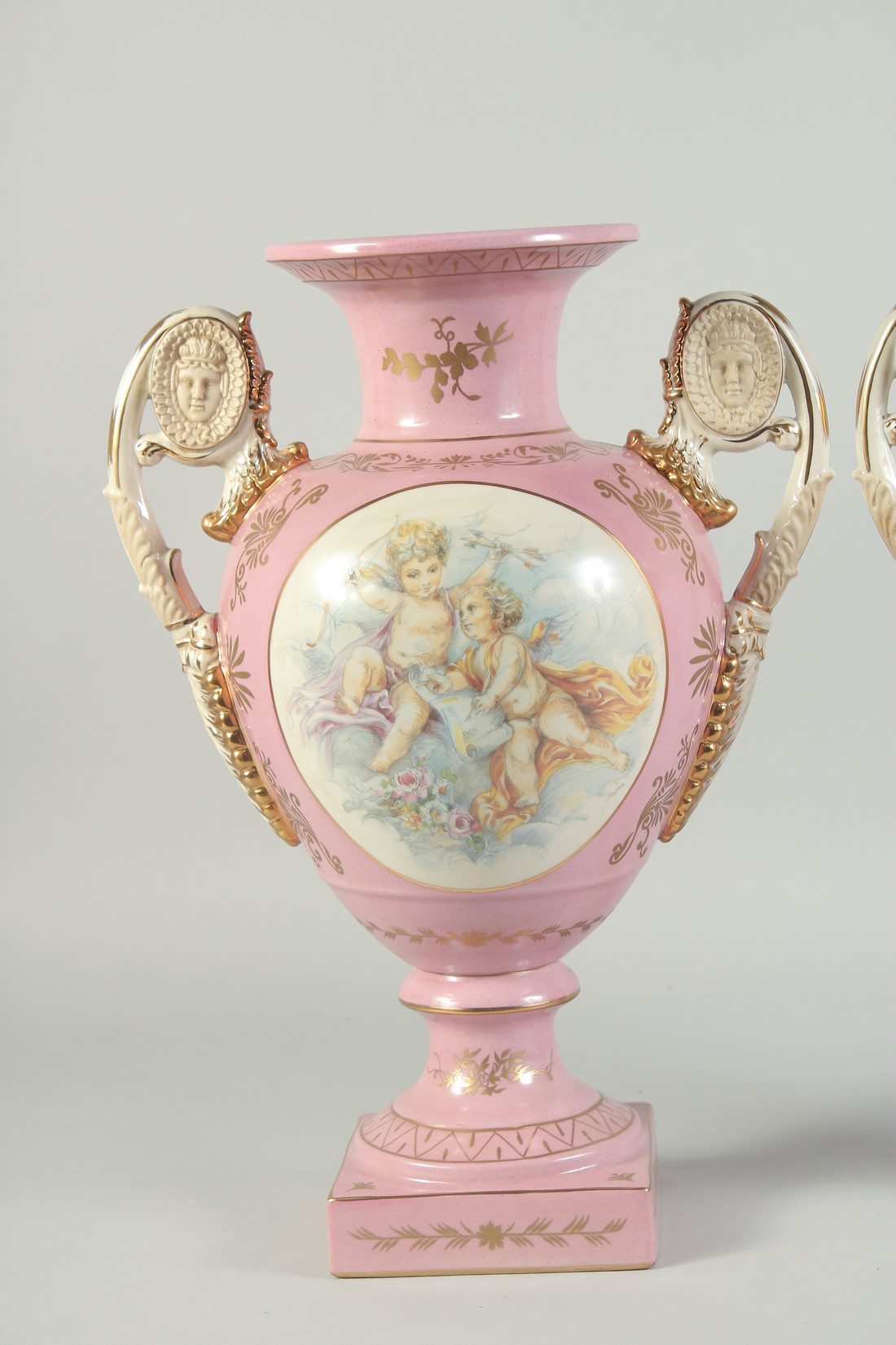 A PAIR OF SEVRES STYLE PINK TWO HANDLED VASES with oval panels of cupids. 1ft 4ins high. - Image 2 of 4