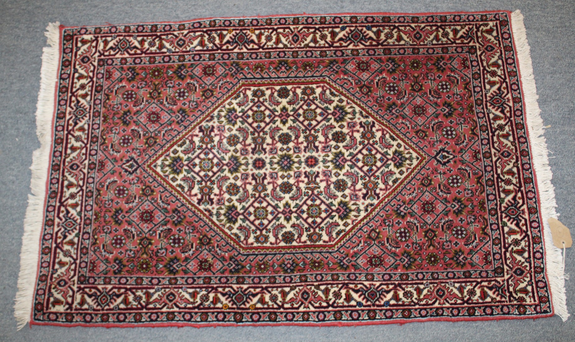 A SMALL PERSIAN RUG with stylised decoration on a rust ground. 106cm x 70cm.