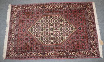 A SMALL PERSIAN RUG with stylised decoration on a rust ground. 106cm x 70cm.