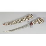 A COWRIE SHELL COVERED DAGGER AND SHEATH. 18ins long.