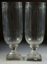 A GOOD PAIR OF SLICE CUT GLASS HURRICANE LAMPS on square bases. 13ins high.