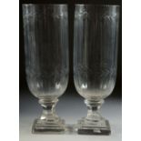 A GOOD PAIR OF SLICE CUT GLASS HURRICANE LAMPS on square bases. 13ins high.