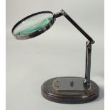 WATT & SONS LTD. A BRONZED MAGNIFYING GLASS on a stand.