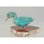 A TURQUOISE DUCK on an agate base. 3ins long.