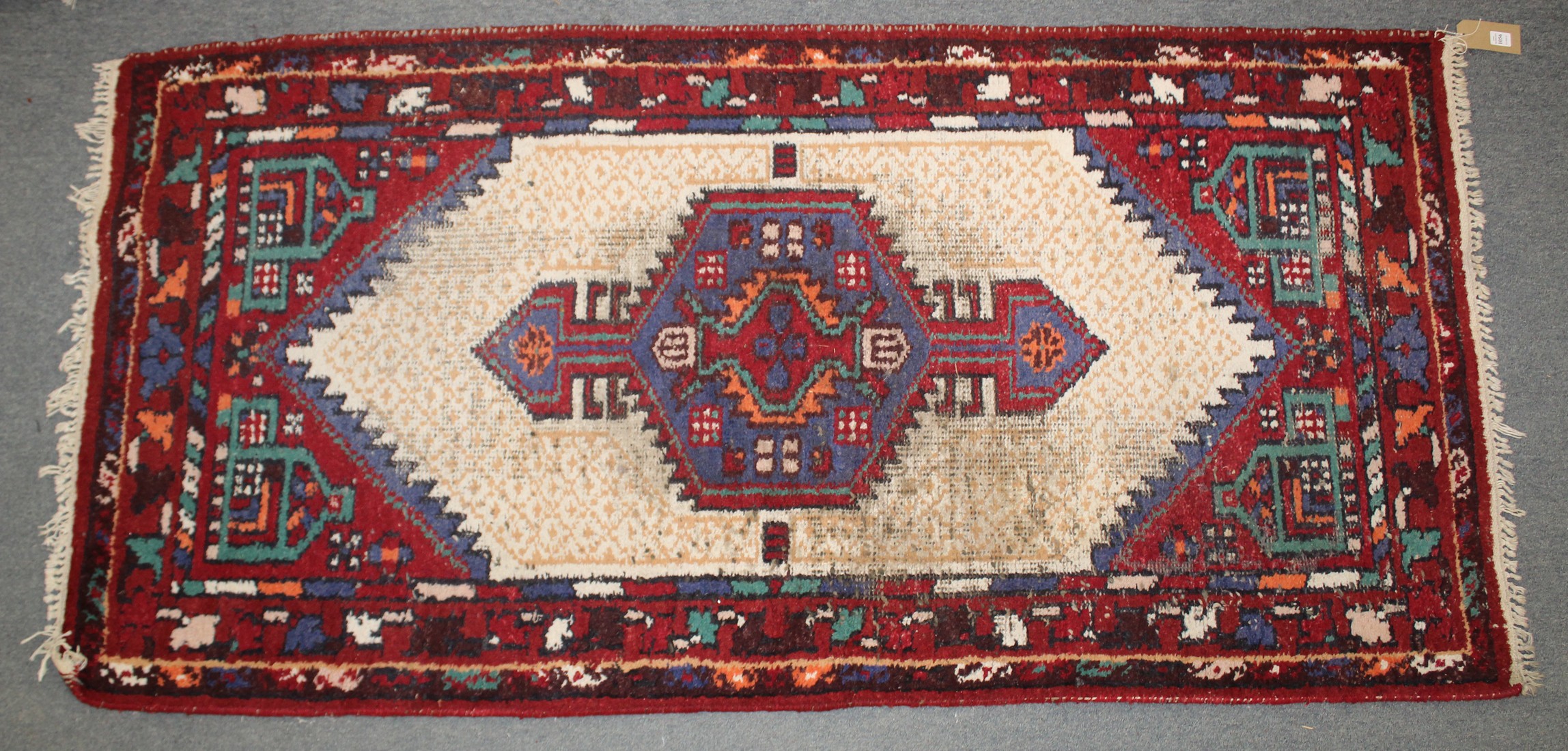 A PERSIAN RUG with geometric panels. 201cm x 94cm.
