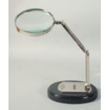 WATT & SONS LTD SILVERED MAGNIFYING GLASS on a stand.