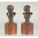 F. BARBEDIENNE. A PAIR OF MINIATURE BRONZE BUSTS, on wooden bases. 2ins high. signed.