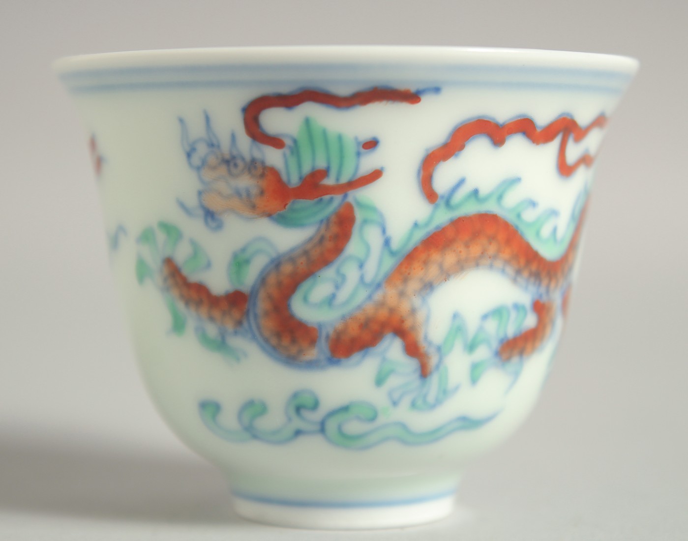 A CHINESE DOUCAI PORCELAIN DRAGON CUP, 6.5cm diameter.