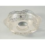 A PIERCED CIRCULAR SILVER FRUIT BOWL on three claw and ball feet. 9ins high, Birmingham 1935. Maker: