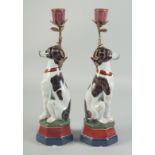A PAIR OF SEATED PORCELAIN DOGS with candle sconces. 1ft 1ins high.