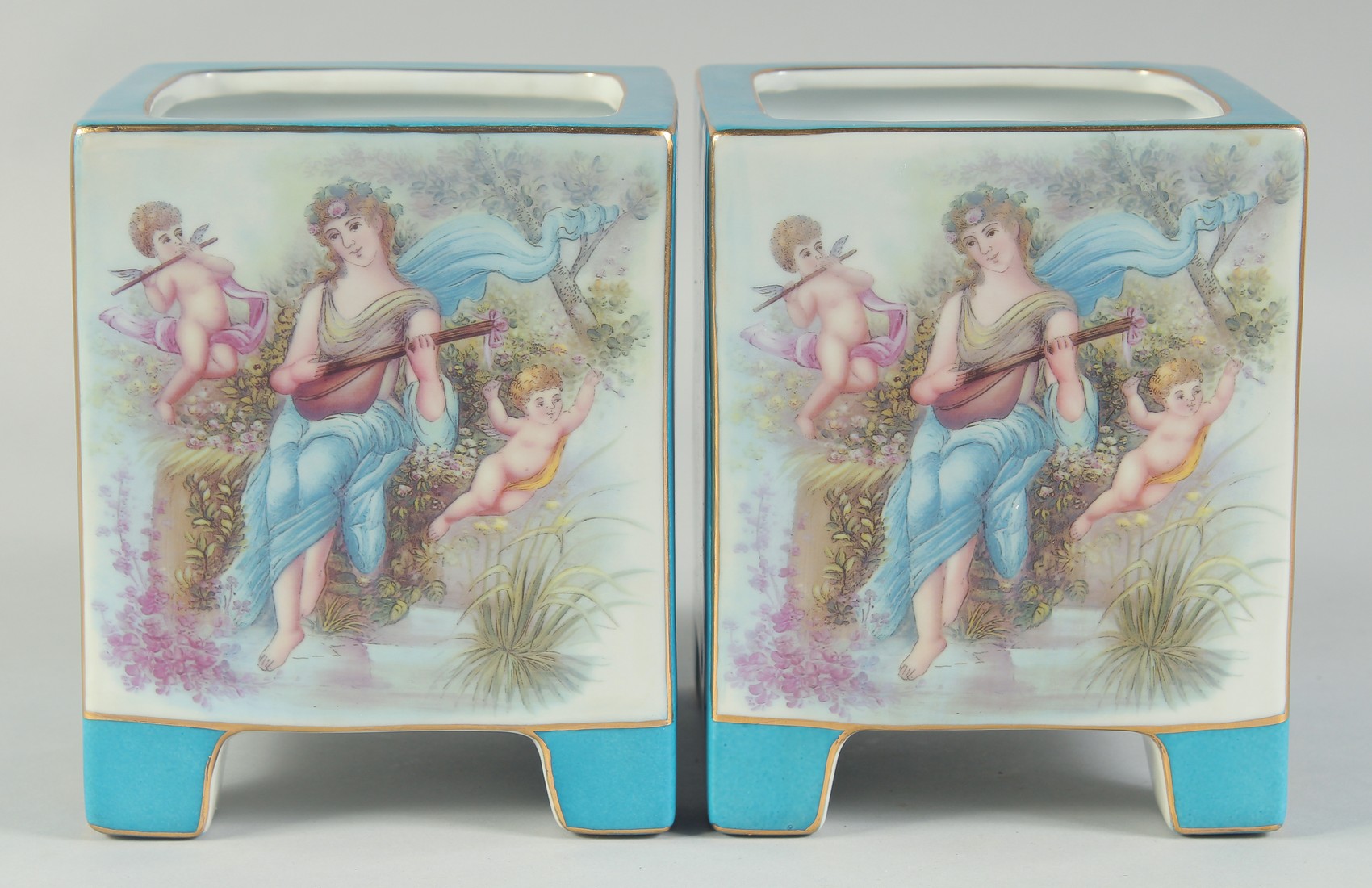 A PAIR OF SEVRES STYLE BLUE SQUARE CACHES POTS with panels of classical flowers. 7ins high.