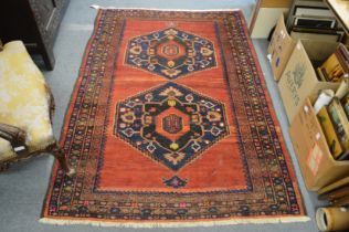 A PERSIAN RUG red ground with two large medallions. 6ft 2ins x 4ft 2ins.