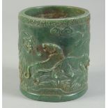 A CHINESE CARVED JADE CIRCULAR BRUSH POT carved with figures. 4.5ins high.