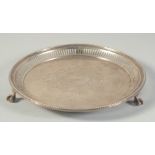 A VICTORIAN SILVER CIRCULAR SALVER with pierced and bead edge on three claw and ball feet. 7.5ins