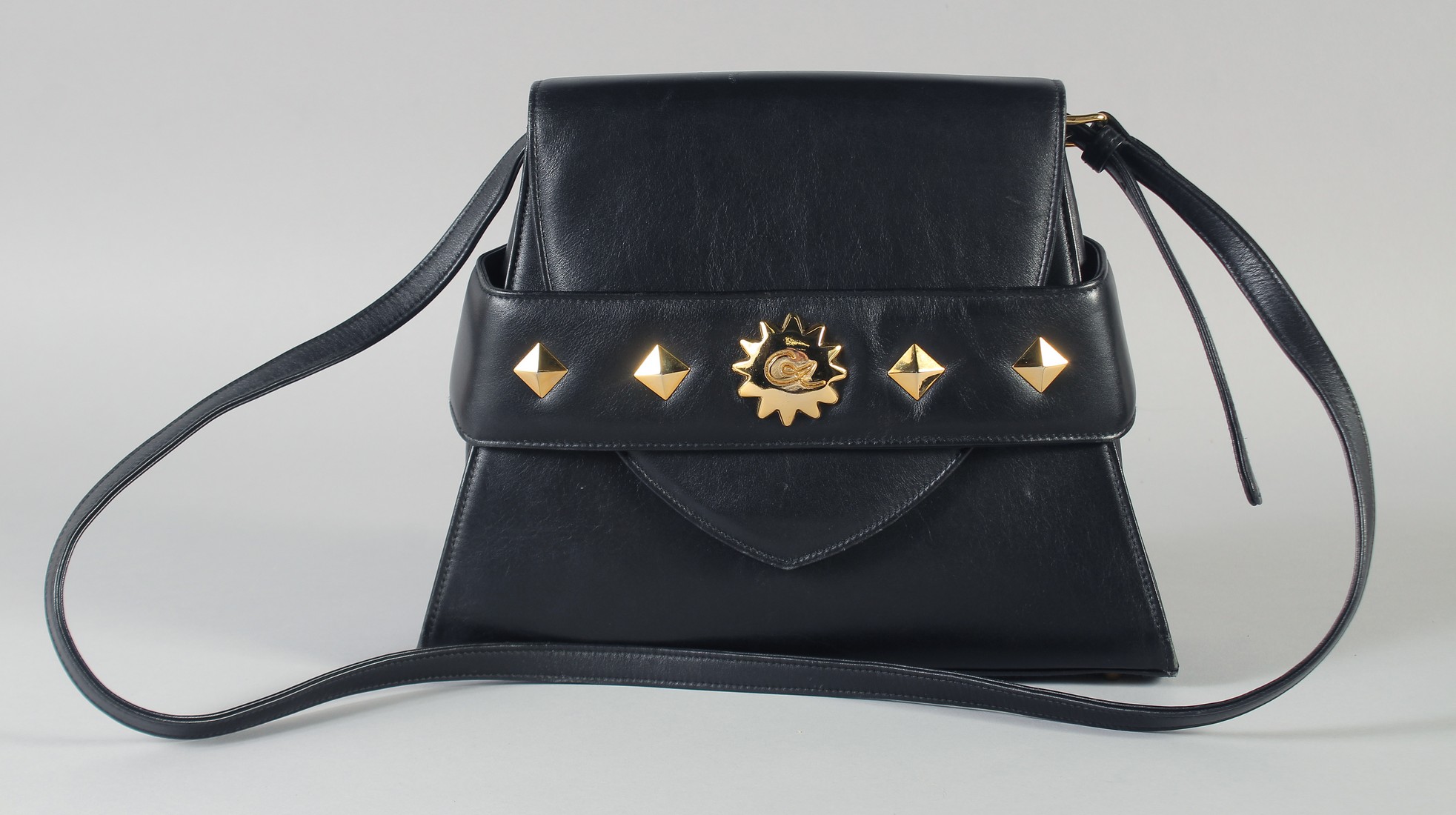 A CHRISTIAN LACROIX BLACK LEATHER HANDBAG with brass studs. 28cm long x 23cm high.