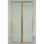 A PAIR OF LONG FRAMED AND GLAZED LACE PANELS 33ins x 7ins.