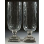 A GOOD PAIR OF OVAL CUT GLASS HURRICANE LAMPS on square bases. 15.5ins high.