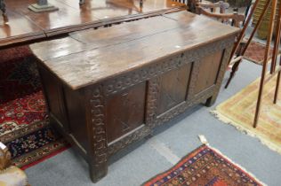 AN 18TH CENTURY OAK COFFER with plank top, triple panel front with panelled ends. 4ft 8ins long x