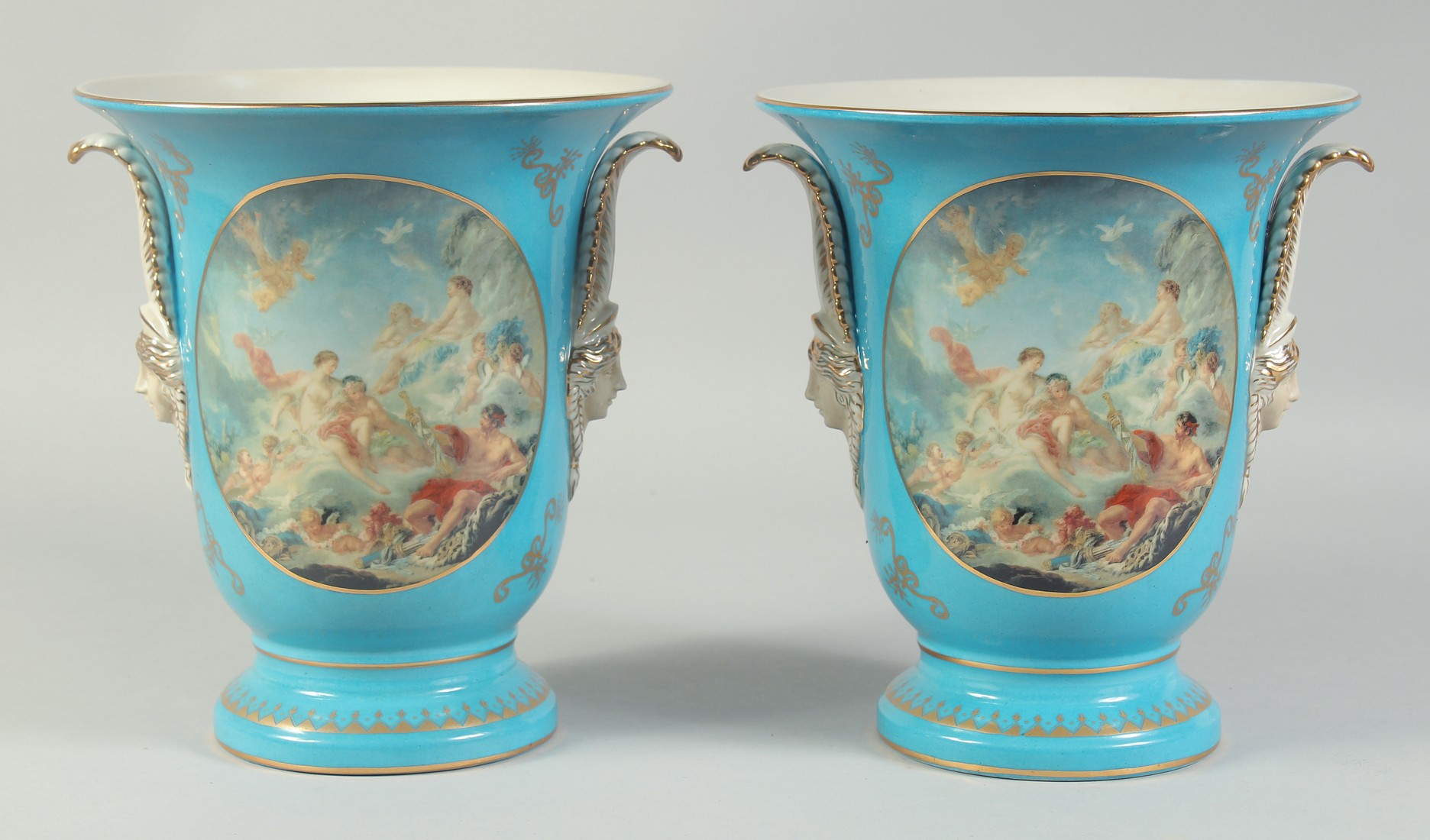 A PAIR OF SEVRES STYLE LIGHT BLUE VASES with panels of classical scenes. 10ins high.