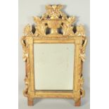AN 18TH CENTURY ITALIAN GILTWOOD MIRROR with urn and flora surmount. 2ft 4ins high, 1ft 7ins wide.