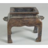 A CHINESE BRONZE RECTANGULAR CENSER on legs. 5ins high.