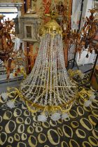 A LARGE BRASS AND CUT CRYSTAL CHANDELIER with scrolling branches having frosted glass shades.