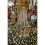 A LARGE BRASS AND CUT CRYSTAL CHANDELIER with scrolling branches having frosted glass shades.